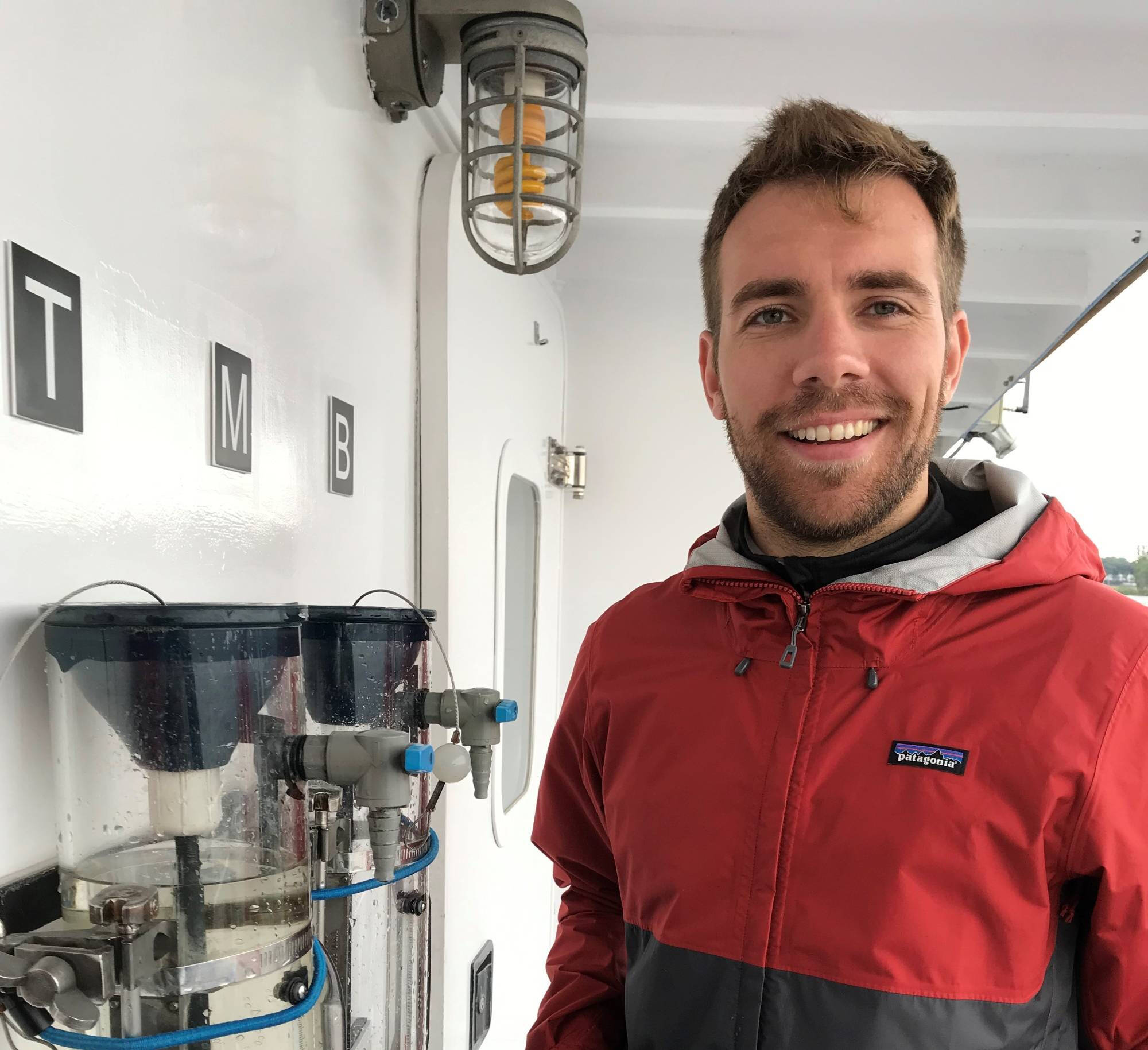 Dr. Sean Woznicki poses for a photo by a water sampling station on AWRI's W.G. Jackson research vessel.